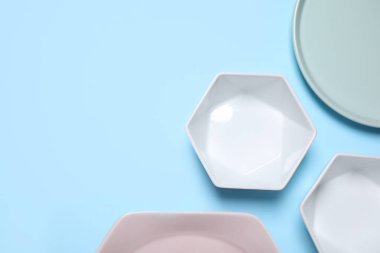 Açık mavi arka planda seramik bulaşık takımı, düz. Metin için boşluk