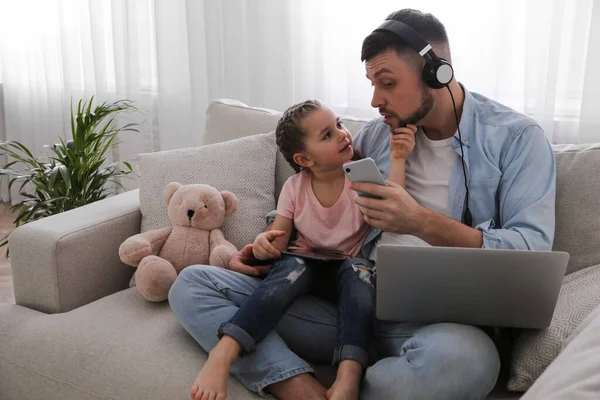 Multitasking man combining parenting and work at home