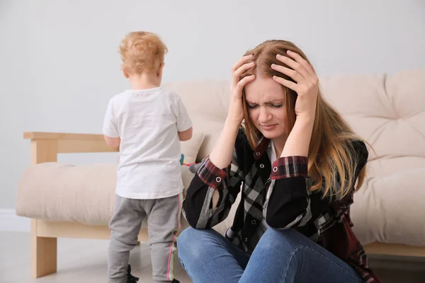 Depressed single mother with child in living room