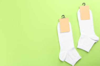 Açık yeşil arka planda yumuşak pamuklu çoraplar, düz yatış. Metin için boşluk