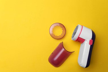 Modern kumaş traş makinesi ve sarı arka planda düz bir döşeme. Metin için boşluk