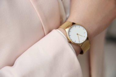 Bulanık arka planda lüks kol saati olan kadın, yakın plan.