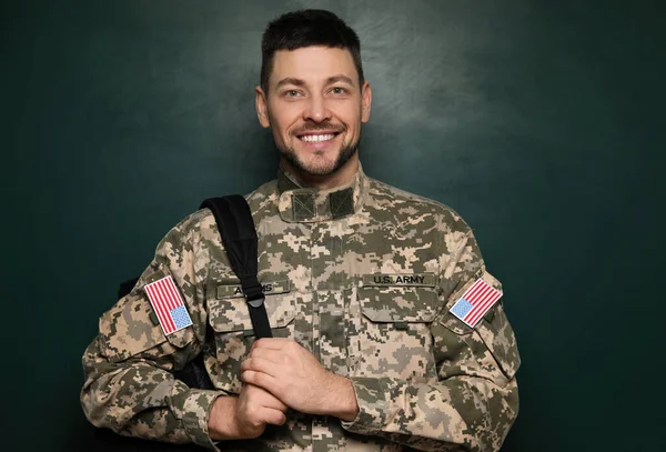 Cadet with backpack near chalkboard. Military education