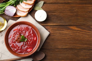 Ahşap masa üzerinde servis edilen Ukrayna borsch ile süslü kahverengi kil kase. Metin için boşluk