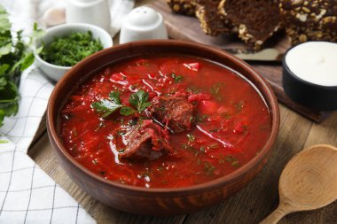 Ahşap masa üzerinde Ukrayna borsch 'u olan şık kahverengi kil kase