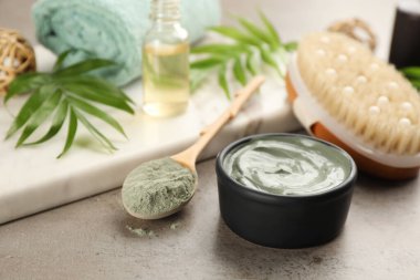 Açık gri taş arka planda vücut kaplaması için kozmetik ürünü