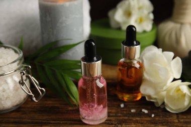 Ahşap masanın üzerinde gerekli yağları olan şişeler. Spa ürünleri