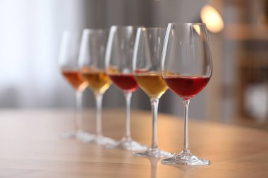 İçerideki ahşap masada tatmak için hazırlanmış farklı türde şarap.