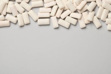 Açık gri arka planda bir sürü sakız parçası var. Metin için boşluk