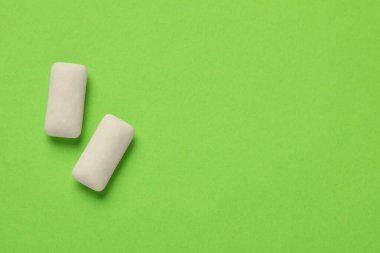 Yeşil arka planda sakız parçaları, düz yatış. Metin için boşluk