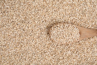 Ahşap kaşıkla pişirilmemiş beyaz kinoa, üst manzara.