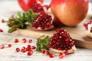 Lezzetli olgun narlar beyaz ahşap masada, yakın plan.