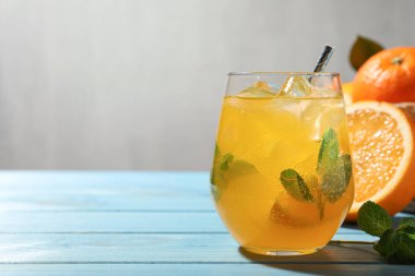 Açık mavi ahşap masada lezzetli portakallı soda. Metin için boşluk