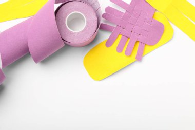 Parlak Kinesio bant rulo ve beyaz arka planda parçalar düz yatıyordu. Metin için boşluk