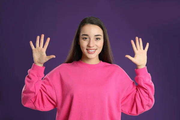 Женщина Показывающая Номер Десять Руками Фиолетовом Фоне — стоковое фото