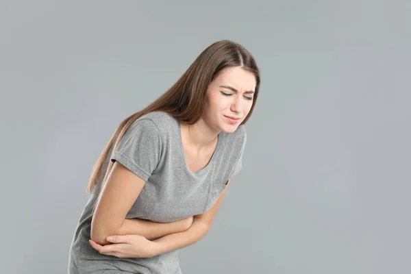 灰色の背景に胃の痛みに苦しむ女性 テキストのためのスペース 食中毒 — ストック写真
