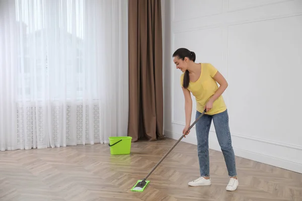 Jovem Mulher Limpeza Chão Com Esfregona Quarto Vazio — Fotografia de Stock