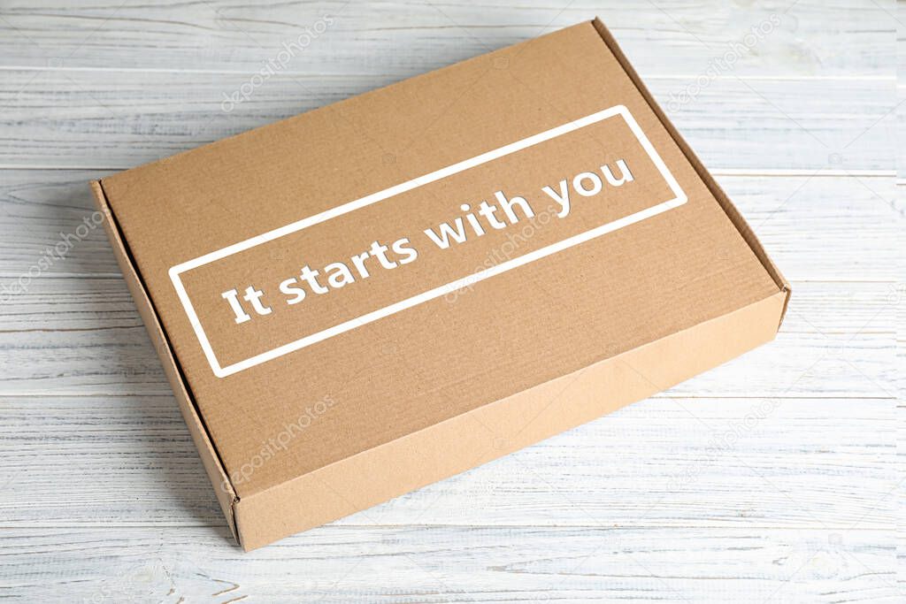 Roles and responsibilities concept. Closed cardboard box with text It stars with you on white wooden table