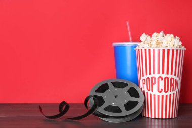 Lezzetli patlamış mısır, içki ve film makarası ahşap masada. Metin için boşluk
