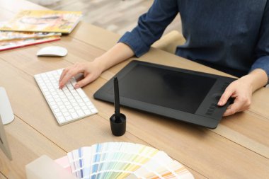 Profesyonel tasarımcı masadaki grafik tablet üzerinde çalışıyor, yakın plan