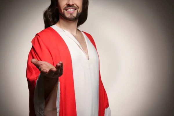 Jesus Christ reaching out his hand on beige background, closeup. Space for text