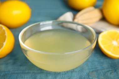 Mavi masadaki cam kasede taze sıkılmış limon suyu.