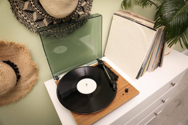 Turntable ve vinil plak koleksiyonu beyaz şifonyer içinde