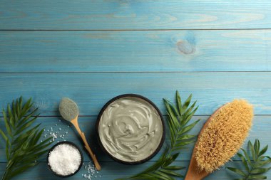 Açık mavi ahşap zemin üzerinde kozmetik ürünü ile düz kompozisyon, metin için boşluk. Kaplıca gövdesi sargıları