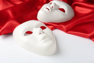 Tiyatro maskeleri ve beyaz arka planda kırmızı kumaş