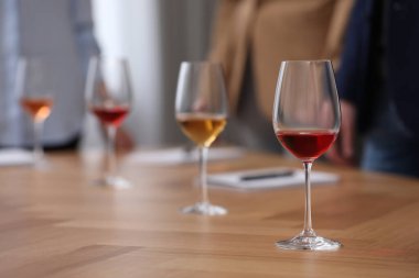 Şarap tadımı sırasında şarap garsonları not alıyor. Kapalı bir masa, yakın çekim.