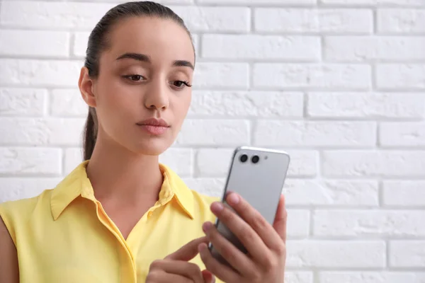 Mujer Joven Desbloqueando Smartphone Con Escáner Facial Cerca Pared Ladrillo — Foto de Stock