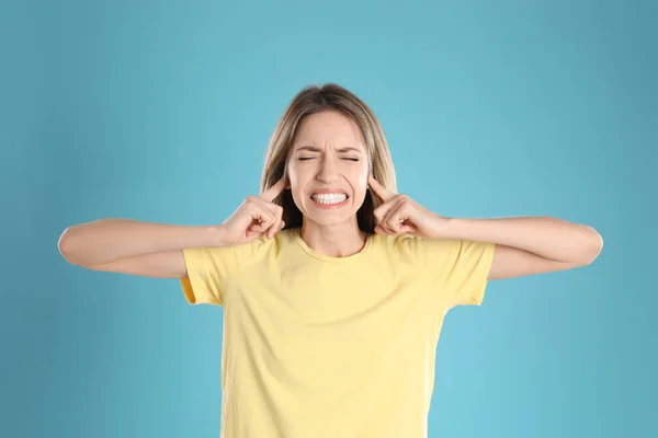 Emotional Young Woman Covering Her Ears Fingers Light Blue Background — Stock Photo, Image