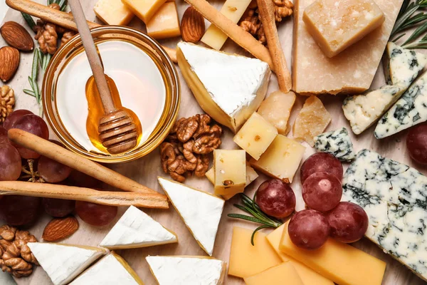 Käseteller Mit Honig Trauben Und Nüssen Auf Holzbrett Von Oben — Stockfoto