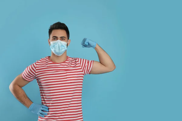 Man Protective Mask Gloves Showing Muscles Light Blue Background Space — Stock Photo, Image