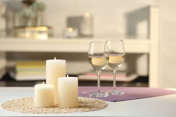 白いテーブルの上でワインのろうそくとガラスを燃やす屋内 — ストック写真