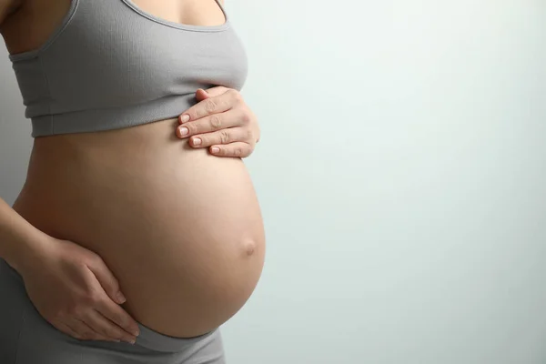 Zwangere Jonge Vrouw Raakt Buik Lichte Achtergrond Close Ruimte Voor — Stockfoto