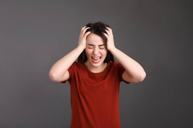 Koyu gri arka planda duygusal genç kadın portresi. Kişilik kavramı