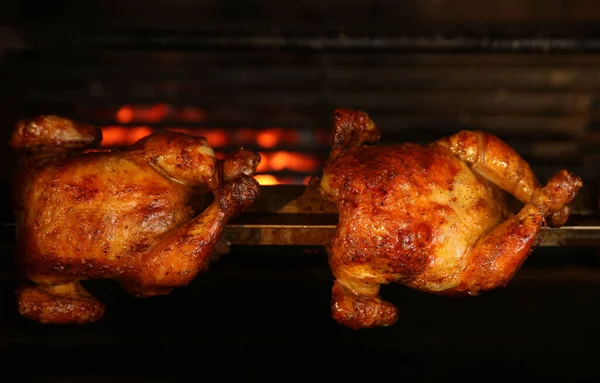 Grilling whole chickens in rotisserie machine, closeup