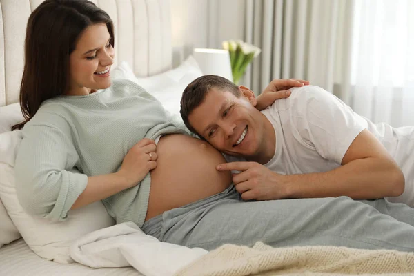 若いです妊娠中の女性とともに彼女の夫でベッドルーム — ストック写真