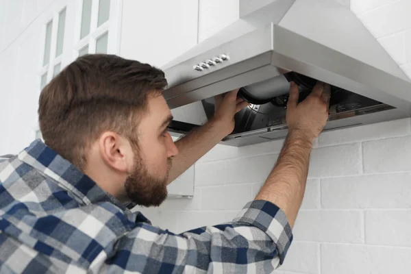 Homem Reparando Capuz Moderno Fogão Cozinha — Fotografia de Stock