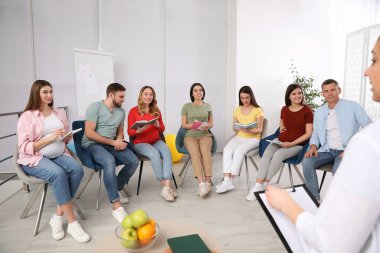 Hamile bir grup kadın erkek ve doktorla birlikte evde bekleyen ebeveynler için kurslarda.