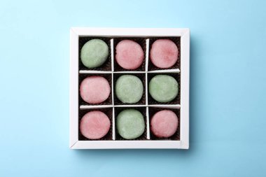 Açık mavi arka planda, kutuda birçok farklı lezzetli mochi, üst manzara. Geleneksel Japon tatlısı