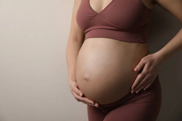 Zwangere Jonge Vrouw Raakt Buik Beige Achtergrond Close Ruimte Voor — Stockfoto