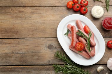 Tahta masada vejetaryen sosis ve sebzelerle bezenmiş düz bir kompozisyon. Metin için boşluk