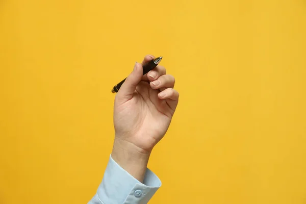 Mulher Canhota Segurando Caneta Fundo Amarelo Close — Fotografia de Stock