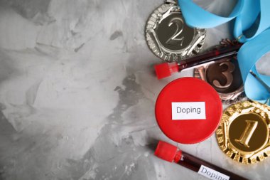 Madalyalar, kan ve idrar örnekleri açık gri taş arka planda Doping kelime ile, düz yatıyordu. Metin için boşluk