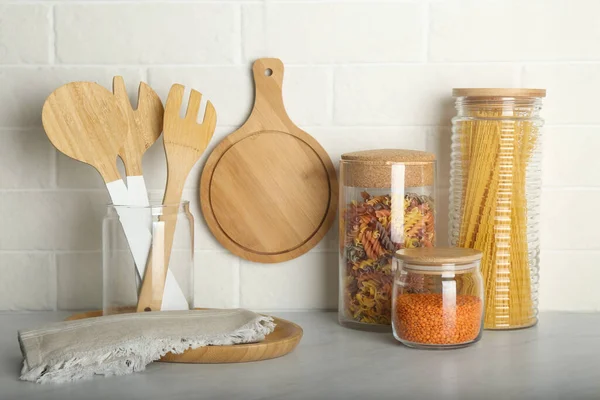 Utensílios Madeira Produtos Diferentes Tabela Cinzenta Perto Parede Branca Tijolo — Fotografia de Stock