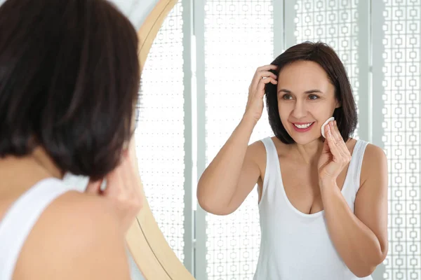 Mulher Madura Feliz Limpeza Rosto Com Almofada Algodão Perto Espelho — Fotografia de Stock