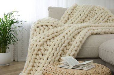 Odadaki kanepede örülmüş merino yün ekose.