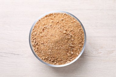 Tabakta taze ekmek kırıntıları, beyaz ahşap masa, üst manzara.